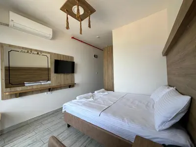 a bedroom with a bed with a mirror and a tv at Kerpe Askoroz Otel in Kandıra