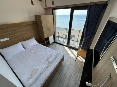 a bedroom with a bed and a view of the beach at Kerpe Askoroz Otel in Kandıra