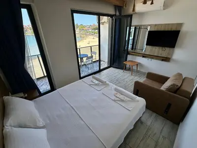 a bedroom with a bed and a couch and a television at Kerpe Askoroz Otel in Kandıra