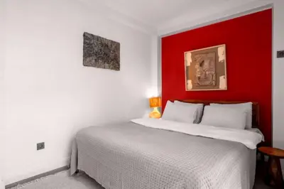 a bedroom with a white bed with a red headboard at Boho-Chic 1BR in Firuzaga - Near Galata in Istanbul