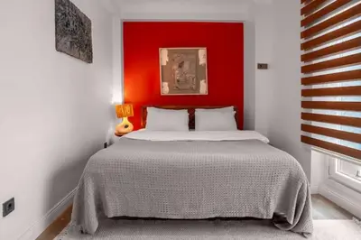 a bedroom with a bed with a red headboard at Boho-Chic 1BR in Firuzaga - Near Galata in Istanbul