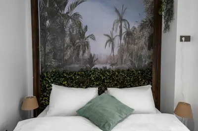 a bedroom with a bed with a painting on the wall at Forest Inspired Designed 1BR Luxury Flat In Tomtom in Istanbul