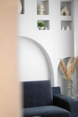 a living room with a blue chair and shelves at Luxury 1BR Duplex with Terrace & Office in Tomtom in Istanbul