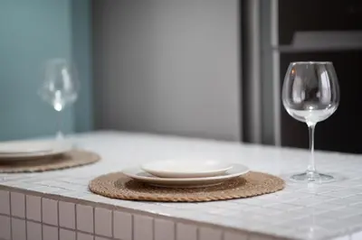 two wine glasses and a plate on a counter at Luxury 1BR Duplex with Terrace & Office in Tomtom in Istanbul