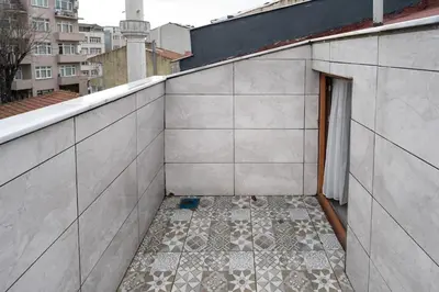a room with a tile floor on the side of a building at Luxury 1BR Duplex with Terrace & Office in Tomtom in Istanbul