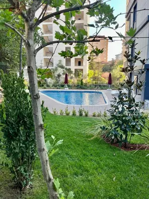 a swimming pool in a yard with a tree at Istanbul Bostanci Family Modern Residence with Pool in Istanbul
