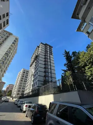 a parking lot with cars parked in front of a tall building at Istanbul Bostanci Family Modern Residence with Pool in Istanbul