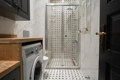 a bathroom with a shower and a washing machine at Designed 2BR Rooftop Duplex with Private Terrace in Istanbul