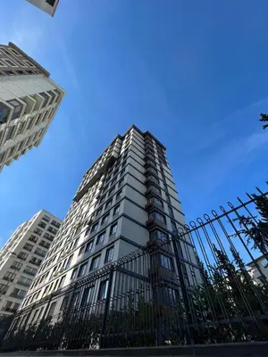 a tall white building with a fence in front of it at Köylüm Bostanci Residence-3 in Istanbul