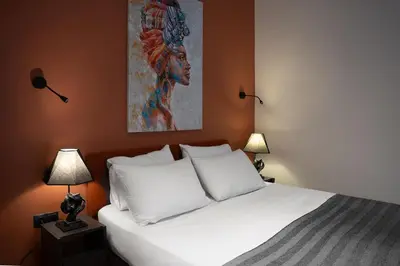 a bedroom with a bed with two lamps and a painting at Charming 1BR Flat with Balcony in Cihangir in Istanbul