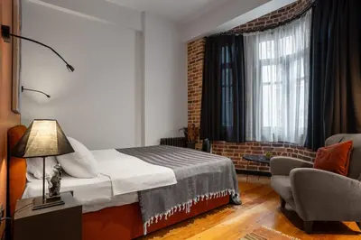 a bedroom with a bed and a chair and a window at Charming 1BR Flat with Balcony in Cihangir in Istanbul