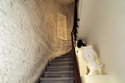 a staircase with a statue next to a brick wall at Magnova Studios in Istanbul
