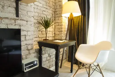 a black table with a lamp and a white chair at Magnova Studios in Istanbul