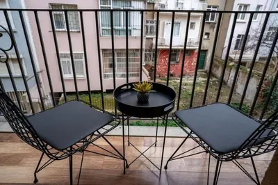 a balcony with two chairs and a table with a plant at Cozy Urban 1BR Nest with Balcony Charm in Istanbul