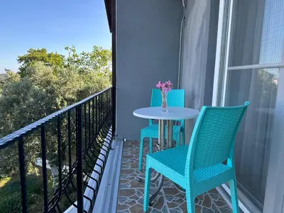 a patio with two chairs and a table on a balcony at ADASU Otel in Marmara