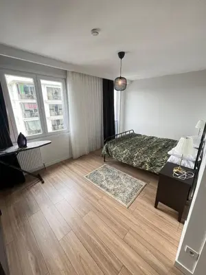 a bedroom with a bed and a desk and two windows at Suadiye Bostanci Luxury 2 Bedroom Apartment with Pool in Istanbul