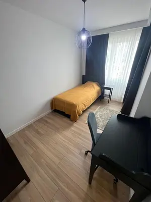 a small bedroom with a bed and a table at Suadiye Bostanci Luxury 2 Bedroom Apartment with Pool in Istanbul