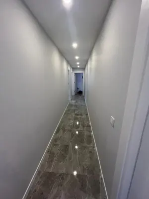 a hallway with white walls and a tile floor at Suadiye Bostanci Luxury 2 Bedroom Apartment with Pool in Istanbul