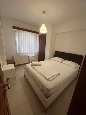 a bedroom with a large bed with white sheets at Ennis İnn Resort Hotel in Marmaraereglisi