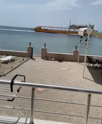 a boardwalk with a pier in the water with a table at Kum Motel in Marmara