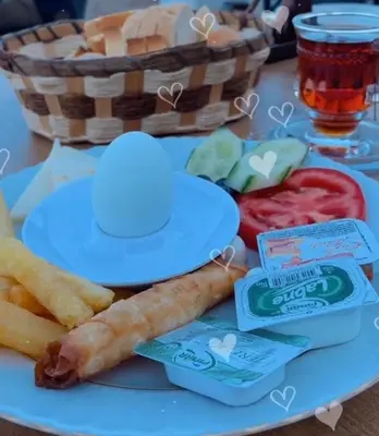 a blue plate with french fries and a basket of food at Kum Motel in Marmara