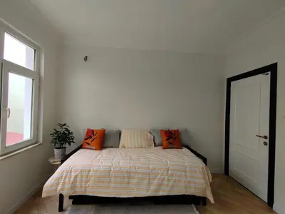a bedroom with a bed with orange pillows and a window at cozy 2BR 2BATH with balcony near to nişantaşi and taksim #4 in Istanbul