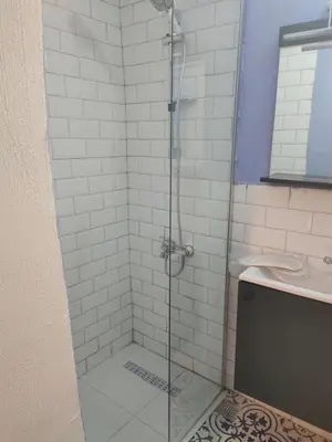 a shower with a glass door next to a sink at baesment 2BR apt with 2toilet and 2bath 8min to metro #1 in Istanbul