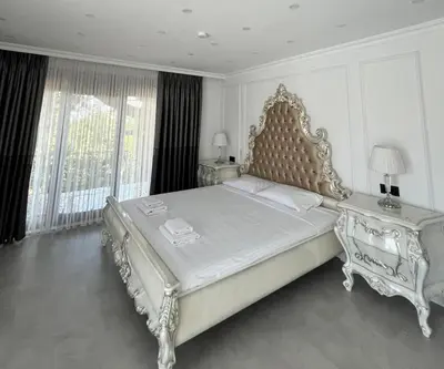a white bedroom with a large bed and two tables at Cloud Nine by Alara - Luxury Private Pool and Garden Villa in Beylikduzu