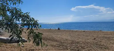 a beach with a boat on the sand and the water at Kalemi Pansiyon in Marmara