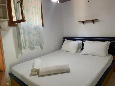 a bed in a small room with a pillow on it at Kalemi Pansiyon in Marmara