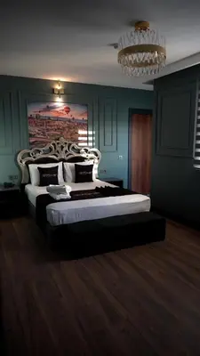 a bedroom with a large bed and a chandelier at Hmz Premium Konaklama Çekmeköy in Çekmeköy