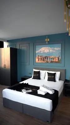 a bedroom with two beds and a painting on the wall at Hmz Premium Konaklama Çekmeköy in Çekmeköy