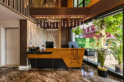 an office with a reception desk and large windows at Airport Waves Hotel in Arnavutköy