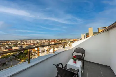 a balcony with two chairs and a table with a view at Airport Waves Hotel in Arnavutköy