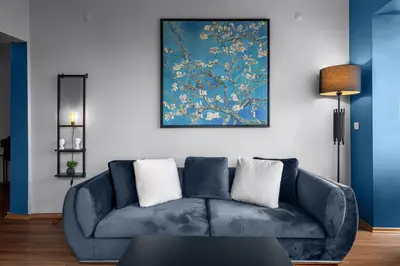 a blue couch in a living room with a painting at Elegant 2BR Haven with Magnificent Bosphorus View in Istanbul