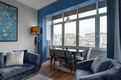 a living room with a table and a blue wall at Elegant 2BR Haven with Magnificent Bosphorus View in Istanbul