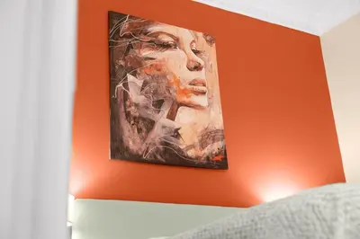 a painting of a woman on an orange wall at Elegant 2BR Haven with Magnificent Bosphorus View in Istanbul