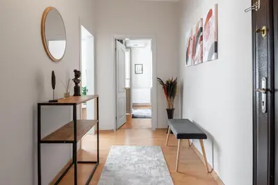 a hallway with a mirror and a table and stool at Fully Equipped & Modern Designed Spectacular 3BR in Istanbul