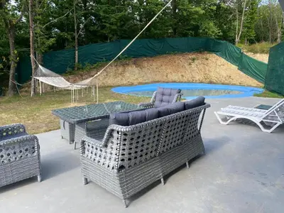 a patio with chairs and a table and a hammock at Kocaeli Başiskele Doğayla İç İçe Özel Havuzlu Tatil Evi in Bahçecik