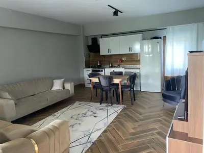 a living room with a couch and a table and a kitchen at Kocaeli Başiskele Doğayla İç İçe Özel Havuzlu Tatil Evi in Bahçecik