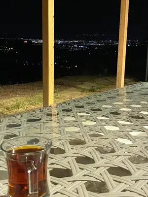 a glass of tea sitting on a table at night at Kocaeli Başiskele Doğayla İç İçe Özel Havuzlu Tatil Evi in Bahçecik