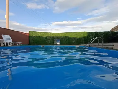 a large swimming pool with blue water in a yard at Kandıra villam in Duraklı