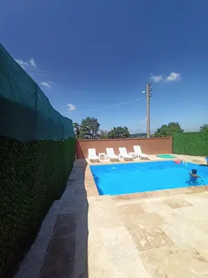 a swimming pool with two chairs and a fence at Kandıra villam in Duraklı