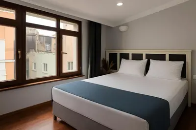 a bedroom with a large bed and two windows at PeraHomes in Istanbul