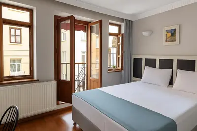 a bedroom with a bed and two windows at PeraHomes in Istanbul