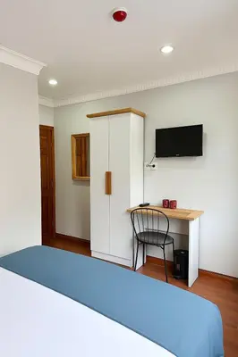 a bedroom with a bed and a desk and a tv at PeraHomes in Istanbul