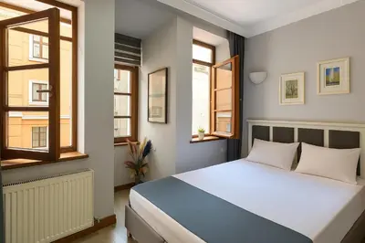 a bedroom with a bed and two windows at PeraHomes in Istanbul