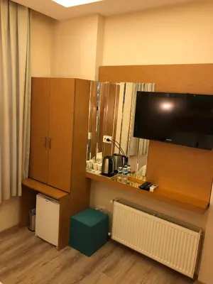 a hotel room with a desk and a tv and a room at Ottoman's Pearl Hotel in Istanbul