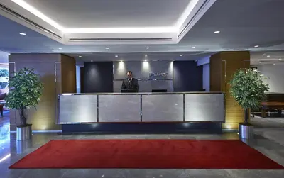 a man standing at a reception desk in a lobby at Milport Hotel Levent Istanbul in Istanbul