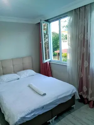 a bed with a white pillow on it in a room with a window at forest villa, breakfast hotel, 6 minutes from Istanbul airport in Arnavutköy
